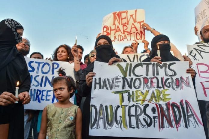people take part in a candlelight march at the India Gate in protest over Kathua gangrape case