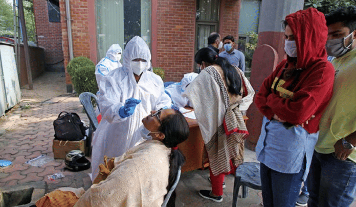 एक महिला का कोविड स्वैब लेता एक स्वास्थ्यकर्मी | ANI