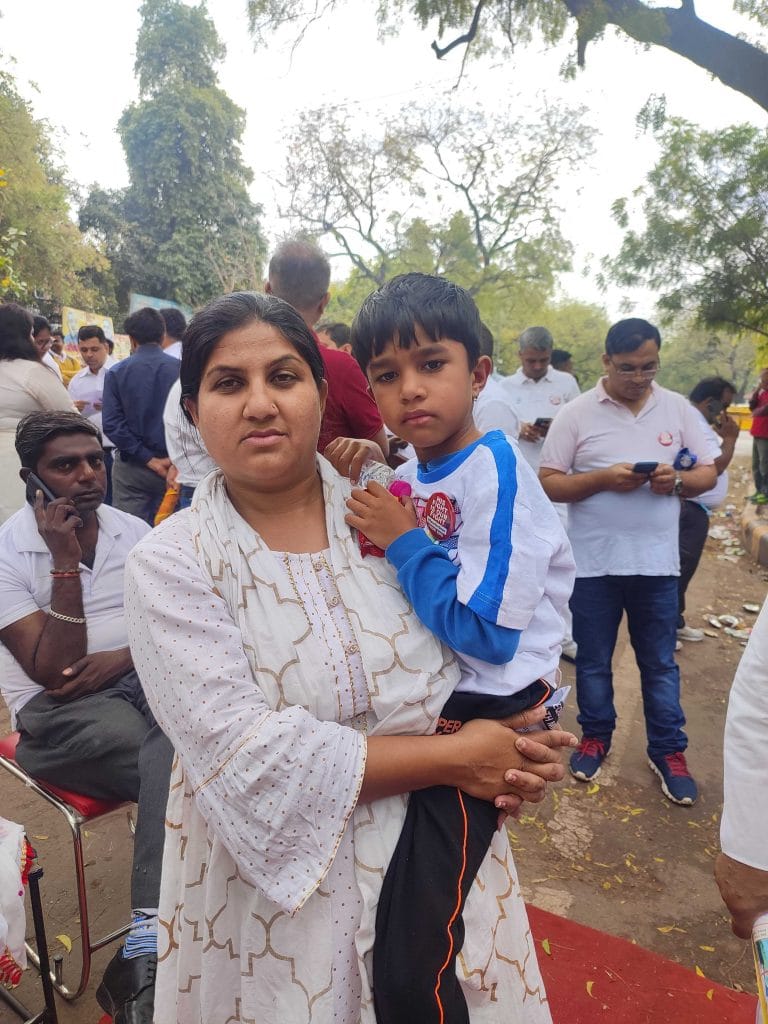 राजस्थान के करौली जिले से आई पूजा अपने बेटे प्रभास को गोद में उठाए हुए | फोटो- फाल्गुनी शर्मा, देबदत्ता चक्रबर्ती/दिप्रिंट