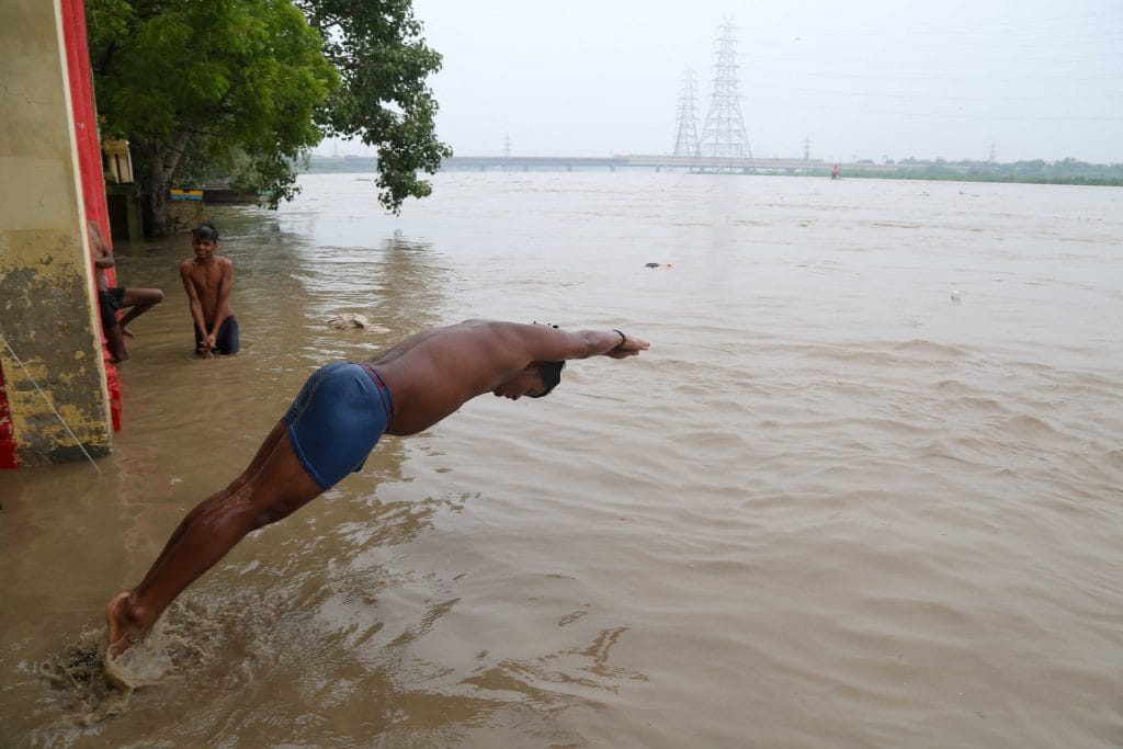 यमुना नदी के खतरे के निशान से ऊपर बह रही है और लोग तैराकी का आनंद उठा रहे हैं | फोटो: सूरज सिंह बिष्ट/दिप्रिंट