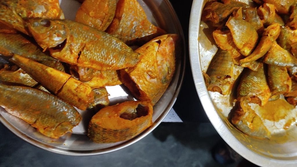 बंगला नंबर सात के घरेलू सहायकों ने मछली को हल्दी-तेल लगाकर मैरिनेट करने के लिए रखा है | फोटो: फाल्गुनी शर्मा/दिप्रिंट