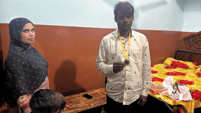 नसीम मलिक ने वह पदक दिखा रहे हैं जो उन्हें फंसे हुए 41 श्रमिकों को बचाने के लिए दिया गया था और उनकी पत्नी समीना उन्हें निहार रही हैं. /ज्योति यादव/दिप्रिंट