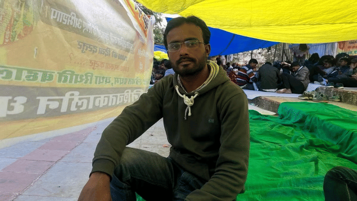 मोहम्मद आबिद, जिन्हें 2021 में पेपर लीक घोटाले के कारण दोबारा परीक्षा देनी पड़ी थी, जयपुर में शहीद स्मारक पर नौकरी की नियुक्ति के लिए विरोध प्रदर्शन कर रहे हैं. उन्होंने परीक्षा तो पास कर ली है, लेकिन एक ‘तकनीकी दिक्कत’ के कारण काम में रुकावट आ गई है | फोटो: मोनामी गोगोई/दिप्रिंट