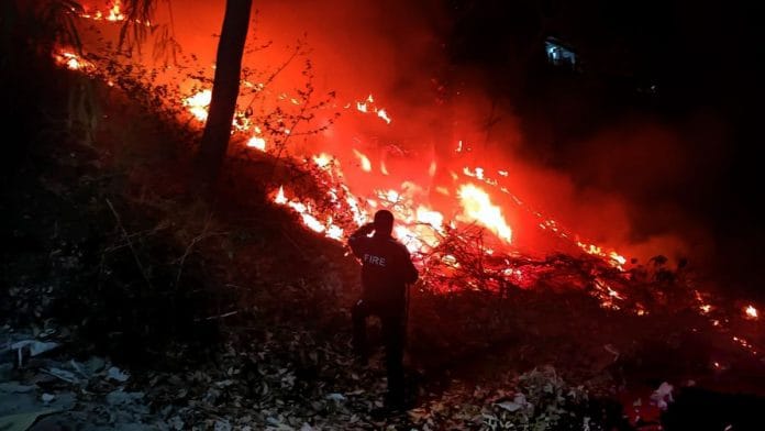 नैनीताल में शनिवार को हल्द्वानी रोड पर स्थित जंगल में भीषण आग लगने के बाद उठता धुआं और लपटें | फोटो: एएनआई
