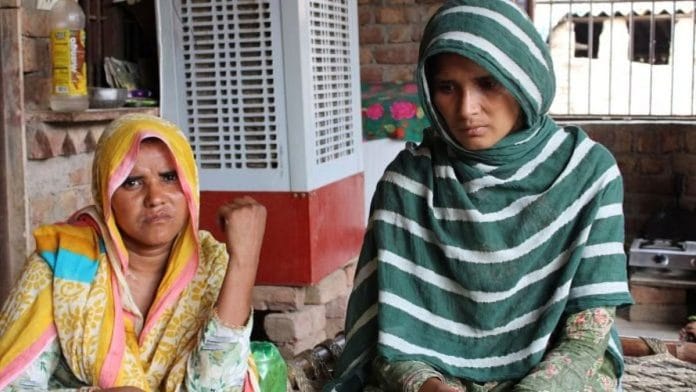 परमीना (बाएं) और साजिदा (दाएं), जिनके पति हरियाणा में गौरक्षकों द्वारा मारे गए थे, एक-दूसरे को सांत्वना देते हुए और अपना दर्द साझा करते हुए, सामाजिक उपेक्षा के बीच अपनी दोस्ती में सांत्वना पाती हैं | फोटो | हिना फ़ातिमा/दिप्रिंट